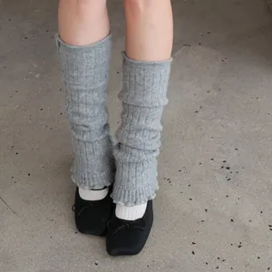 Light gray wool blend leg warmers with vertical knit patterns and ballet flats