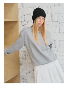 Detailansicht der rosa Stickerei auf einem weichen hellgrauen Baumwoll-Sweatshirt