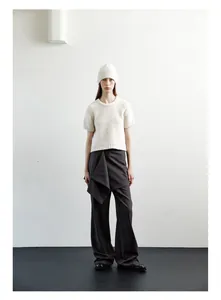 Detail of soft off-white wool knit beanie paired with a minimalist textured sweater