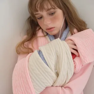 Pink wool blend knit cardigan with beige cable knit scarf for winter warmth