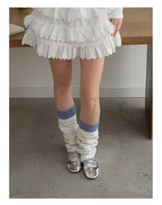 Detail of striped wool knit leg warmers paired with silver ballet flats and lace skirt