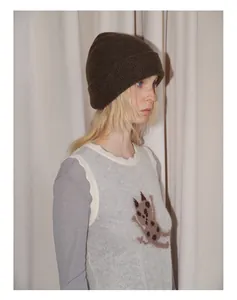 Detail of dark brown knit beanie with 23% yak wool and grey vest with cat pattern
