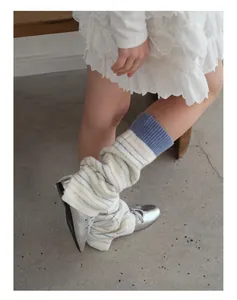 Detail of wool blend striped leg warmers paired with silver Mary Jane shoes in Y2K style