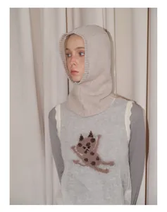 Detail von Balaclava aus reiner Wolle und Strickweste mit Katzenmuster und Wellenrand
