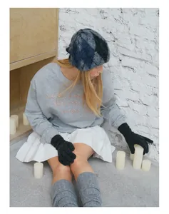 Detailed view of the wool blend checkered knit hat with safety pin and grey sweatshirt
