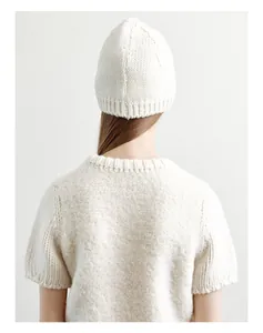 Detailed texture of off-white 50% wool knit beanie and matching plush short sleeve sweater