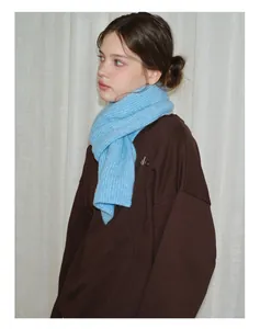 Close-up of sky blue knit scarf with a soft wool texture and minimalist ribbed pattern