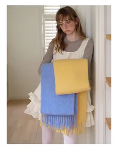 Detail of blue and yellow fuzzy alpaca wool scarves with long tassels for women