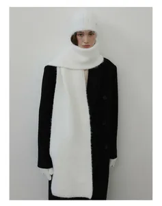 Detail of soft white wool blend knit scarf and beanie paired with a black double-breasted coat