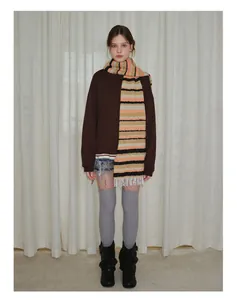 Detail of striped tassel wool blend scarf paired with a brown sweatshirt and denim shorts