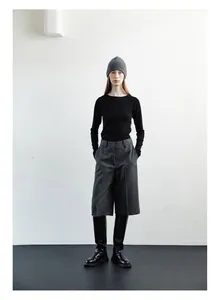 Minimalist grey ribbed wool beanie styled with a black knit top and wide-leg trousers