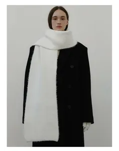 Close-up of thick white wool blend knit scarf paired with a black double-breasted coat