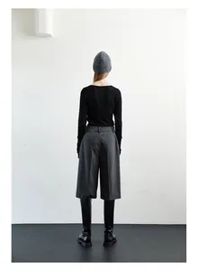 Minimalist winter style featuring grey wool knit beanie with black sweater and leather boots
