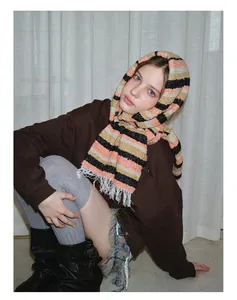 Detailed view of striped wool blend scarf with fringe tassels and winter outfit styling