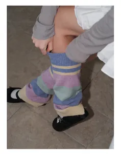 Detailed close-up of y2k style striped knit leg warmers with ribbed wool texture