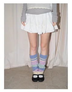 Detail of Y2K striped knit leg warmers in pastel colors paired with Mary Jane shoes