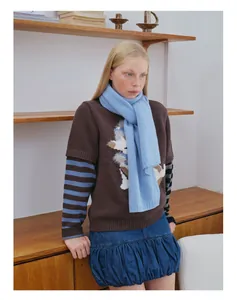 Details des hellblauen Wollschals kombiniert mit einem dunkelbraunen Stickpullover