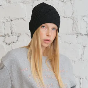 Minimalistische schwarze Strickmütze mit geripptem Muster, getragen am Modell