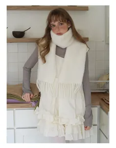 Detailed close-up of fluffy white alpaca wool scarf texture with elegant tassels