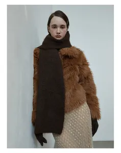 Detail of a thick dark brown knit wool scarf paired with a brown plush faux fur winter coat