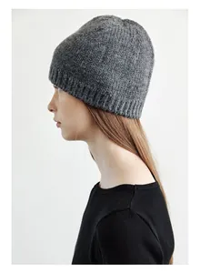 Detail view of the thick rib-knit texture and soft wool blend on this dark grey beanie
