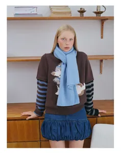 Detailansicht hellblauer Wollschal kombiniert mit einem braun gemusterten Strickpullover