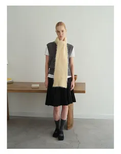 Detailweergave van de crème alpaca wollen sjaal met vest en zwarte rok