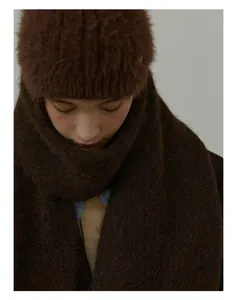 Close-up of thick dark brown wool blend knitted scarf and matching plush winter hat