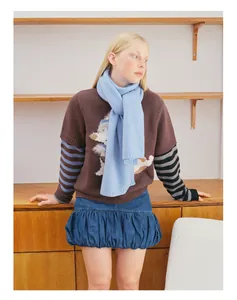 Detailaufnahme eines blauen Wollschals kombiniert mit einem braunen Hundestrickpullover