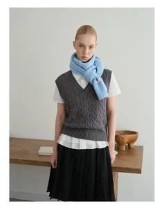 Winteroutfit-Detail mit hellblauem Strickschal und gewebtem Logo-Etikett an einem Model