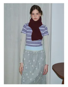 Detailed layered look featuring a burgundy chunky knit wool scarf with a grey star skirt