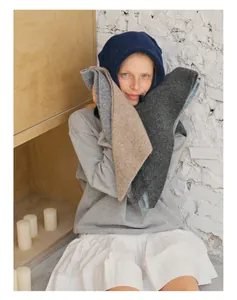 Detailed knit texture of wool blend balaclava and scarves in dark blue and neutral tones