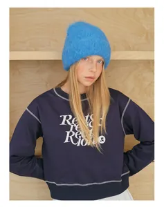 Detail of sky blue fluffy alpaca wool knit beanie paired with navy blue graphic sweatshirt