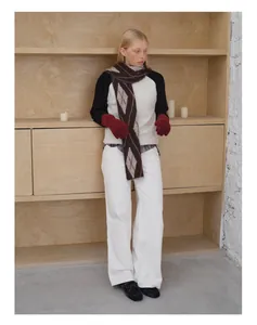 Detailansicht des Winter-Wollschals mit Rautenmuster und roten Strickhandschuhen