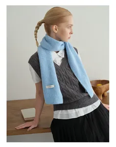 Detailaufnahme des hellblauen Wollschal mit Rippenstrick und gewebtem Markenetikett am Saum