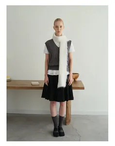 Winteroutfit met witte alpaca gebreide sjaal, antraciet vest en zwarte plooirok