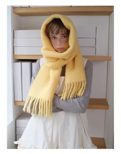 Close-up of soft yellow alpaca wool blend scarf with thick texture and long tassels