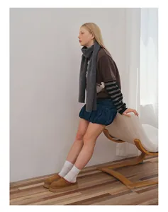 Winteroutfit mit grauem Wollschal, braunem Strickpullover, Jeansrock und Wildlederschuhen