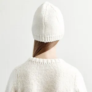 White wool knit beanie cap for women with textured ribbing shown on back of model