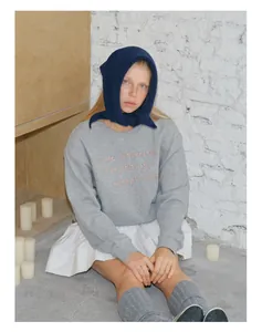 Detailed embroidery on a grey wool blend sweatshirt paired with a blue knit scarf