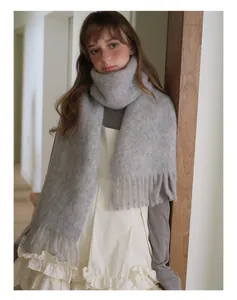 Detail of soft dark grey alpaca wool blend scarf with long fringe on a female model