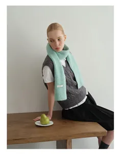 Detail der Strickstruktur des mintgrünen Wollschal mit eingewebtem Markenetikett
