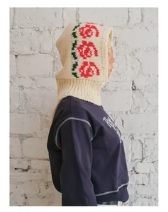 Detail of hand-crocheted floral balaclava with red rose pattern and wool blend texture
