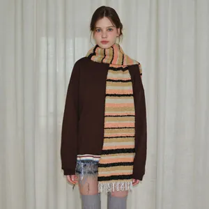 Knitted wool blend scarf with orange and black stripes and white fringe tassels on model