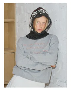 Detailed view of pink embroidery on grey sweatshirt with knit balaclava hood