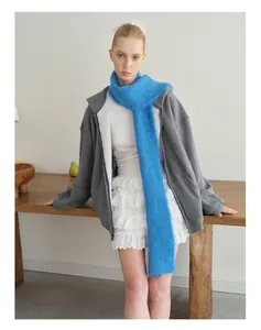 Modedetail van een lange lichtblauwe alpaca sjaal gecombineerd met een grijze hoodie