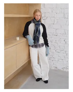 Nahaufnahme von blau-grauem Wollschal mit Rautenmuster und hellblauen Strickhandschuhen