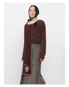 Détail d'une écharpe en tricot de vison synthétique marron avec broderie de fleurs