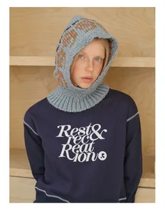 Detail of blue wool blend balaclava with floral jacquard pattern and branded sweatshirt