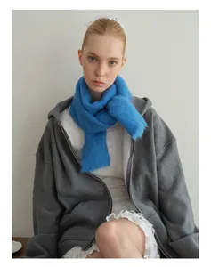 Detail van een pluizige felblauwe alpaca wollen sjaal over een grijze hoodie